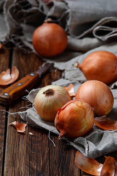istock Raw onions on wooden background 498122736