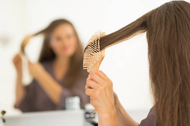 istock young woman combing hair in bathroom. rear view 498126853