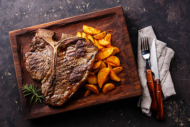 médio t-bone steak grelhado com fatias de batata - beef meat t bone steak steak imagens e fotografias de stock