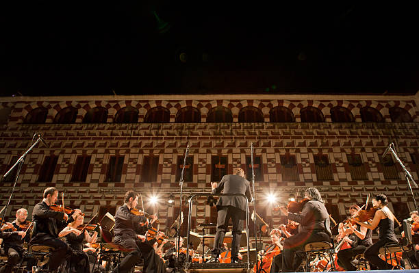 Orchestra at Plaza Alta, Spain Badajoz, Spain - June 16, 2014: Musicians performing at Plaza Alta. The Extremadura Region Classical Music Orchestra performs at the Hight Square of Badajoz, Spain on June 16, 2014 symphony orchestra photos stock pictures, royalty-free photos & images