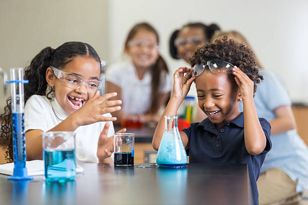 istock Little girls laughing while doing science experiment in classroom 498128723