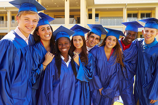 Group Of High School Students Celebrating Graduation Group Of High School Students Celebrating Graduation Smiling To Camera Wearing Gown And Cap high school stock pictures, royalty-free photos & images