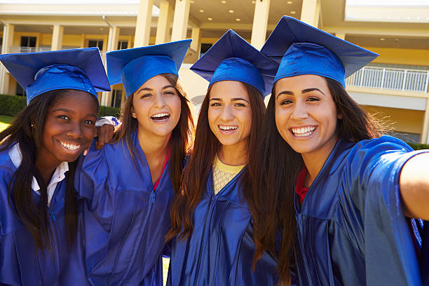 Group Of Female High School Students Celebrating Graduation Group Of Female High School Students Celebrating Graduation Smiling To Camera diverse female graduates stock pictures, royalty-free photos & images