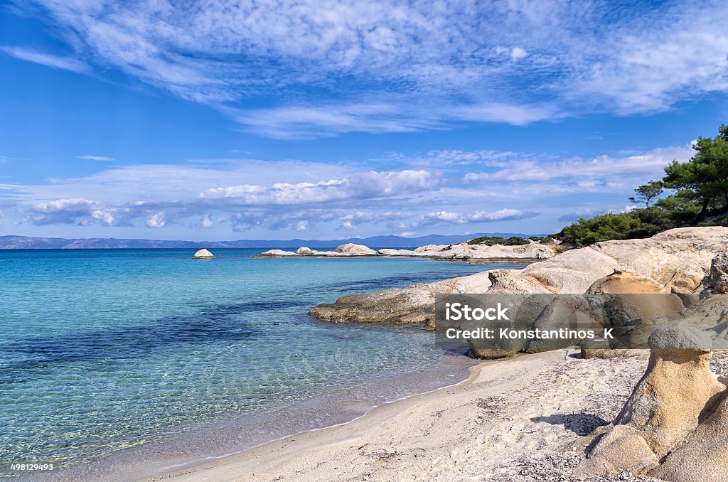 Rocks in a sandy beach in Sithonia, Chalkidiki, Greece Rocks in a sandy beach in Sithonia, Chalkidiki, Greece, with crystal clear water Aegean Sea Stock Photo