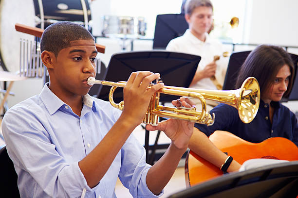 maschio pupilla suonare la tromba nella high school orchestra - ottone strumento a fiato foto e immagini stock