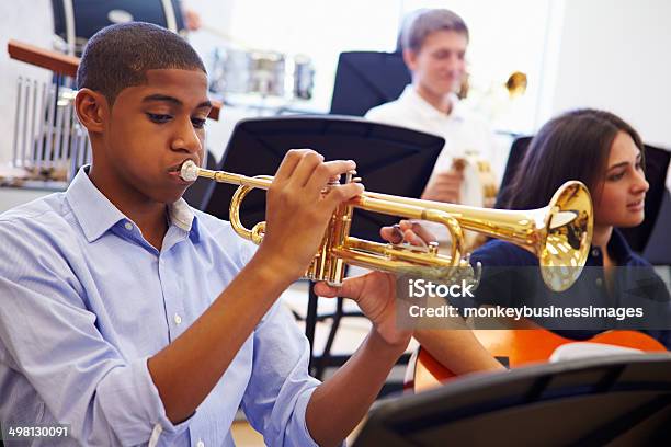 Male Pupil Playing Trumpet In High School Orchestra Stock Photo - Download Image Now