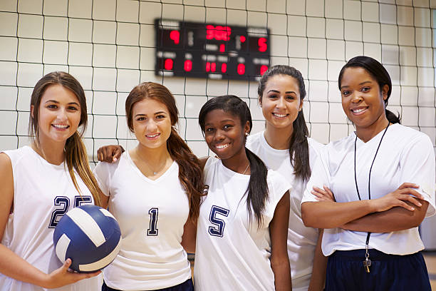 les membres de l'équipe de volleyball féminin école avec entraîneur - sport volleyball high school student teenager photos et images de collection