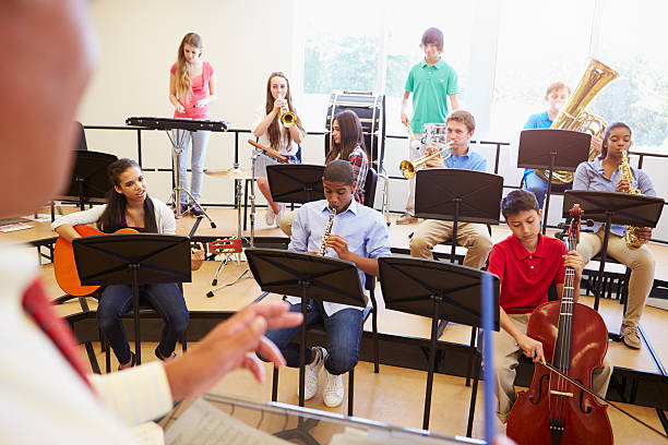 schüler in der schule spielen musikinstrumente orchestra - jugendorchester stock-fotos und bilder
