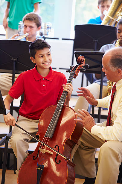 istock Boy Learning To Play Cello In High School Orchestra 498131181