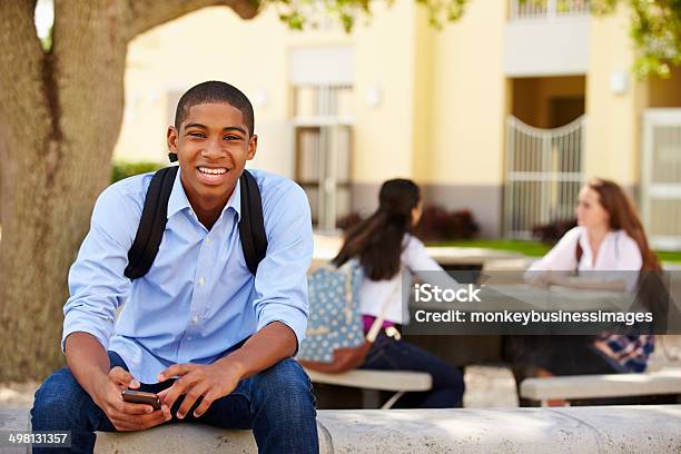 High School Student Hombre Usando El Teléfono En La Escuela Campus Foto de stock y más banco de imágenes de Estudiante de secundaria