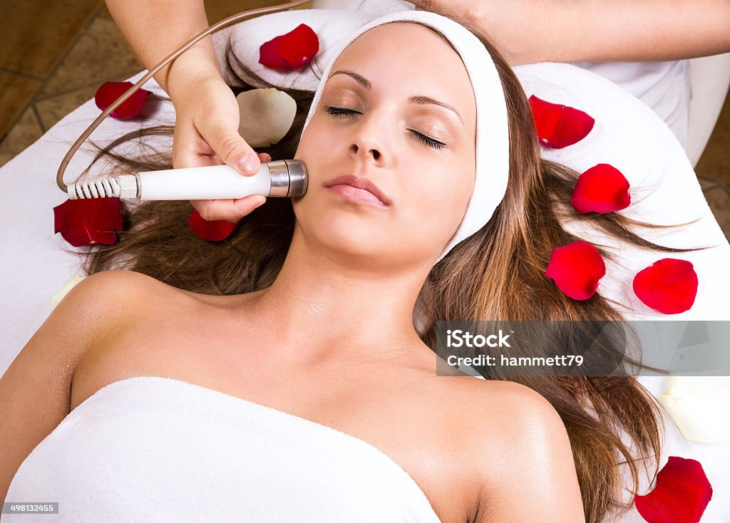 Beautiful woman at the beautician. Woman getting laser and ultrasound face treatment in medical spa center, skin rejuvenation concept Adult Stock Photo