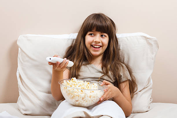istock Little girl watching tv in bed 498140014
