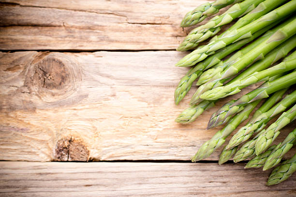 istock Asparagus on the wooden background. 498140426