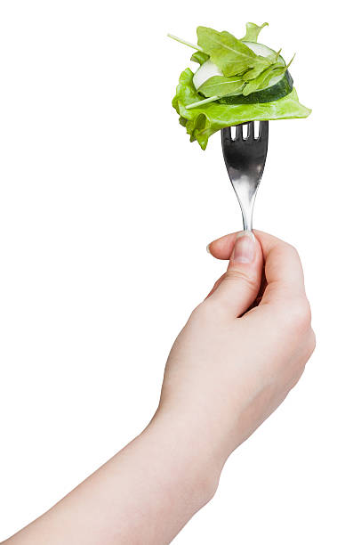 istock fork with impaled fresh green salad in hand 498143634