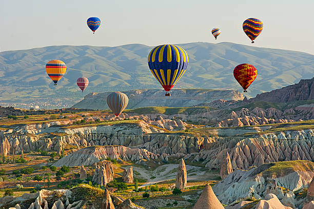 colorate mongolfiere volare sopra la valle a cappadocia, - hot air balloon landscape sunrise mountain foto e immagini stock