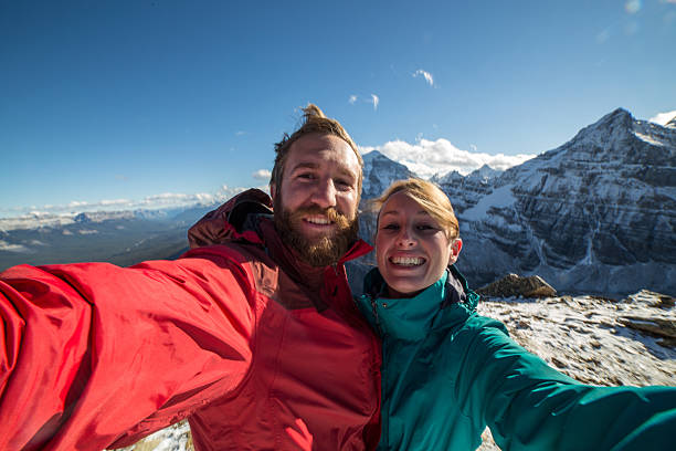 istock Young couple on mountain peak taking a selfie portrait 498145766