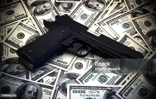 Black And Chrome Gun Pistol And Money Dollars Background Stock Photo - Download Image Now