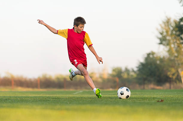 istock kid kicking a soccer ball 498149114