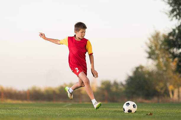 istock kid kicking a soccer ball 498149914