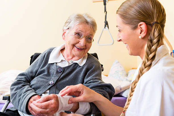 Nurse taking care of senior woman in retirement home stock photo