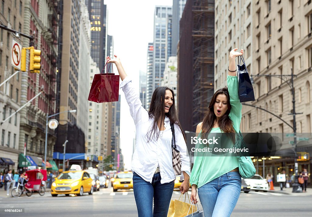 Women in shopping Two female friends walking in the street of New York City with shopping bags and smiling.  New York City Stock Photo