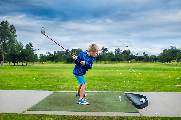 istock Young Boy Hitting A Golf Ball At The Range 498168900