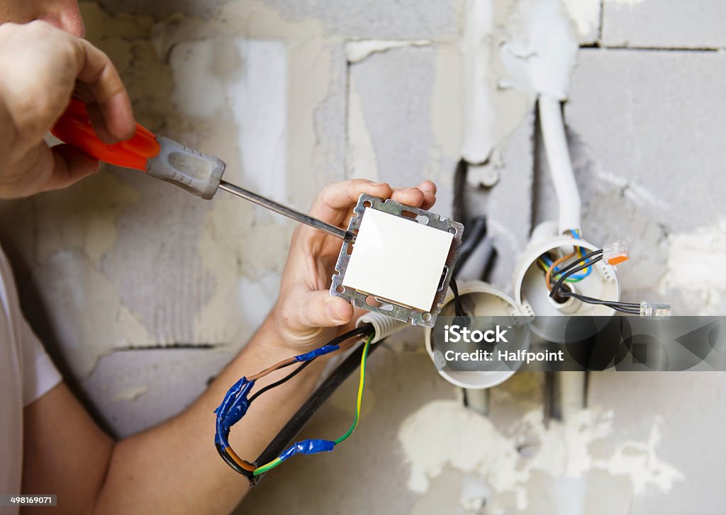 Electrician working Electrician installing light in a new house Adult Stock Photo