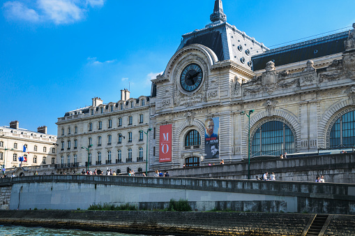 Paris, France - May 31, 2014: Tourists and Parisians stroll along the sidewalk and ramp past the The Musee d'Orsay in Paris  Located in a former railway station,   built between 1898 and 1900 on the left bank of the Seine, the museum houses major 19th- & 20th-century, European art collections