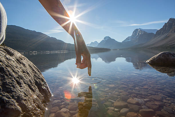 dedo tocar a superfície de um lago de montanha - bow lake imagens e fotografias de stock