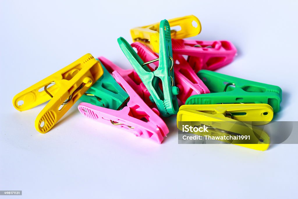 green, yellow and pink clothes peg green, yellow and pink clothes peg isolated on a white background. Blue Stock Photo