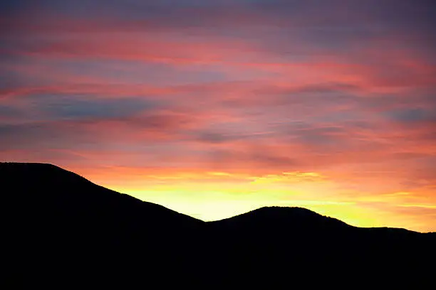 Red sunset above silhouette of the mountains