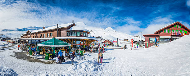 Crowds of skiers at Kleine Scheidegg winter resort Alps Switzerland Kleine Scheidegg, Switzerland - February 27, 2014: Skiers enjoying the snowy winter wonderland of Kleine Scheidegg, the popular mountain resort high in the Bernese Alps of Switzerland. Composite panoramic image created from seven contemporaneous sequential photographs. apres ski stock pictures, royalty-free photos & images