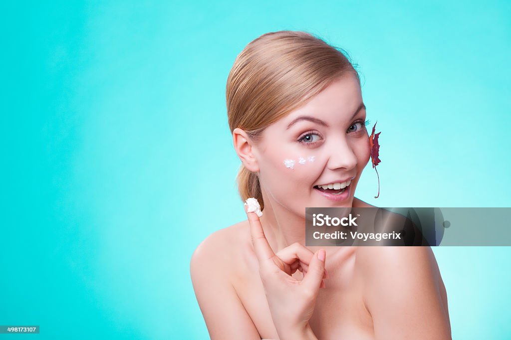 Skin care. Face of young woman girl with leaf cream Skincare habits. Face of young woman with leaf as symbol of red capillary skin on turquoise. Girl taking care of her dry complexion applying moisturizing cream. Beauty treatment. Accidents and Disasters Stock Photo