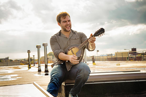Young man rocking his mandolin on Brooklyn rooftop