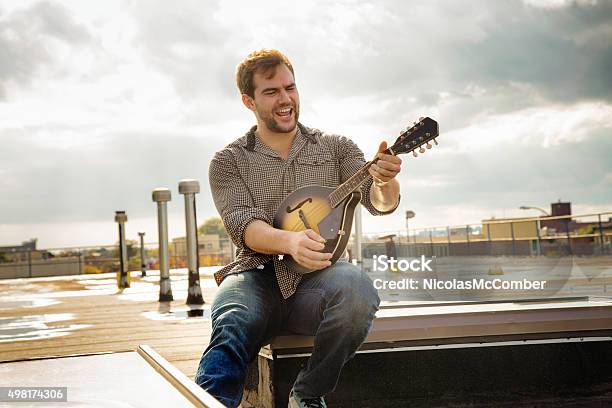 Young Man Rocking His Mandolin On Brooklyn Rooftop Stock Photo - Download Image Now - Mandolin, American Culture, Playing