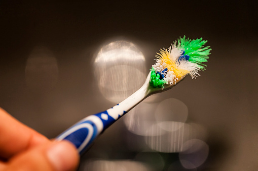 Old and worn toothbrush on dark background