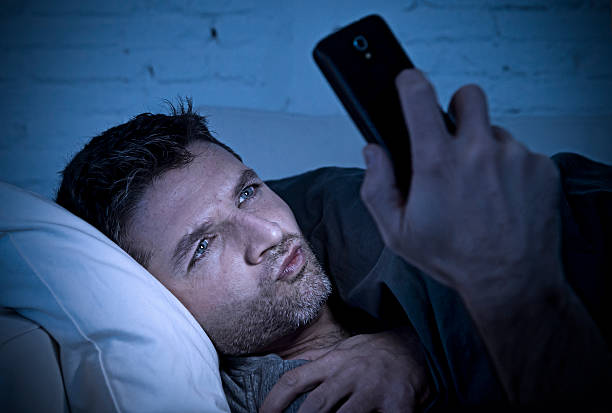homem no sofá usando telefone celular assistir pornografia on-line - sleaze - fotografias e filmes do acervo