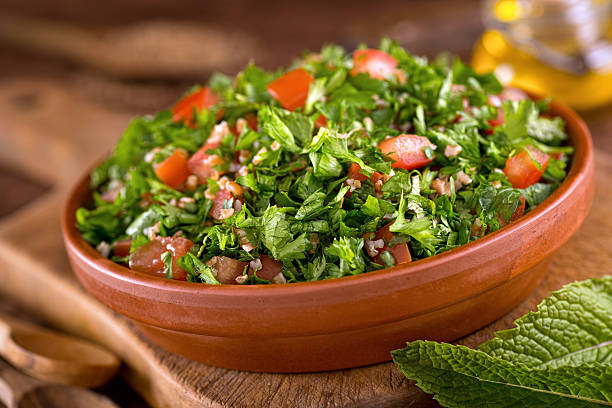 Tabouli A bowl of delicious fresh tabouli with parsley, mint, tomato, onion, olive oil, lemon juice, and bulgar wheat. lebanese culture stock pictures, royalty-free photos & images