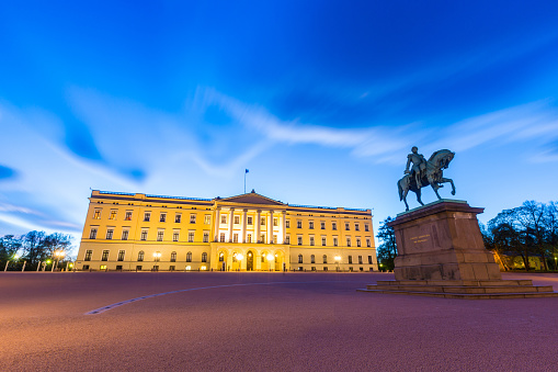 Oslo, Norway - April 22, 2015: Royal Palace and equestrian statue of Karl Johan in Oslo, Norway, at dusk. Long exposure shot with blurred clouds in the sky. Travel and architecture.