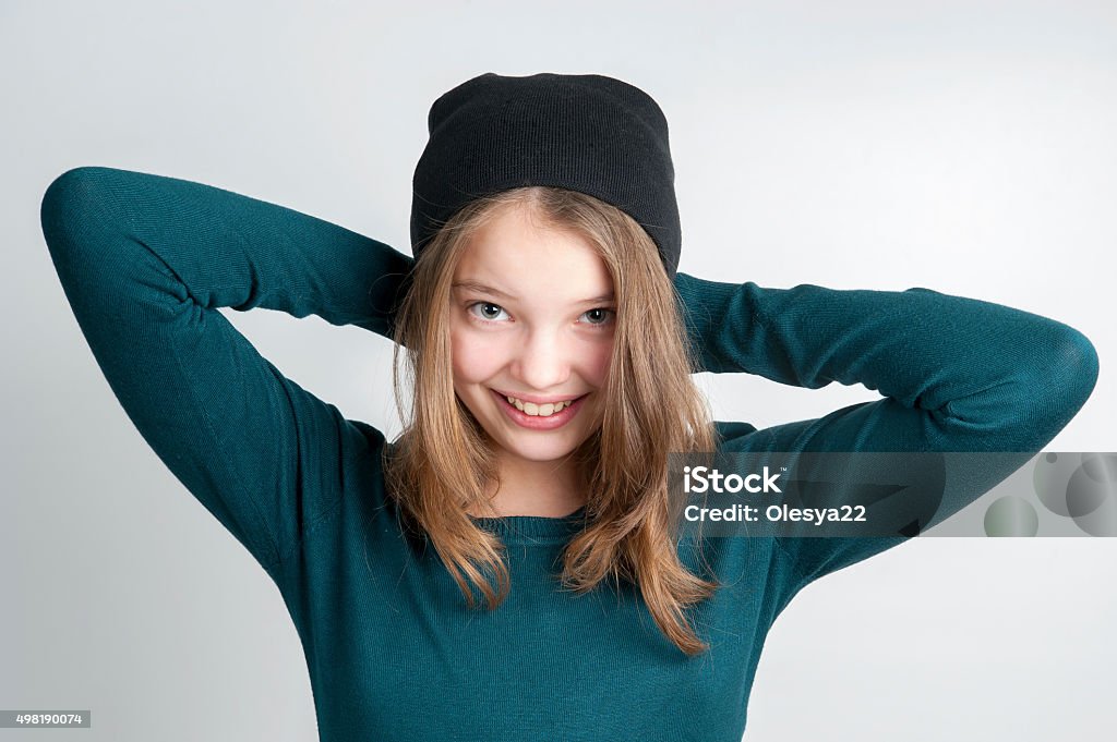 Cute little girl holds hands behind head. Cute little girl holds hands behind head. Studio photography on a light gray background. Age of child 10 years. Teenage Girls Stock Photo