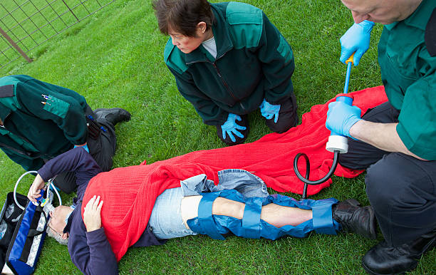 colapso hombre con piernas lesiones paramedics enfermeras en la lista de asistencia - human hand help pain heart attack fotografías e imágenes de stock