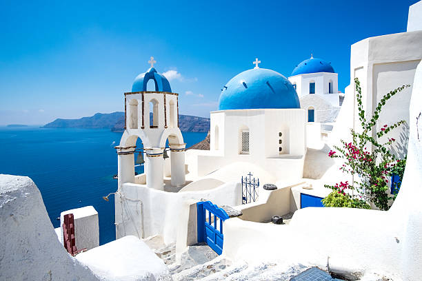 Scenic view of white houses and blue domes on Santorini Scenic view of traditional cycladic white houses and blue domes in Oia village, Santorini island, Greece bell tower tower photos stock pictures, royalty-free photos & images