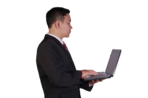 Business concept image of an Asian businessman holding laptop with one hand and typing with the other hand isolated on white