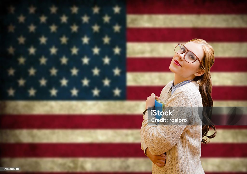 Young woman learning English Picture of pretty girl in big hipster glasses with copybooks. Young student happy smiling on USA flag blurred background. 2015 Stock Photo