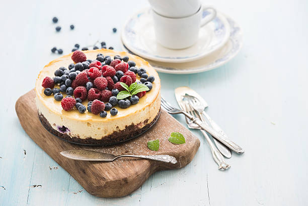 istock Cheesecake with fresh raspberries and blueberries on a wooden serving 498200670