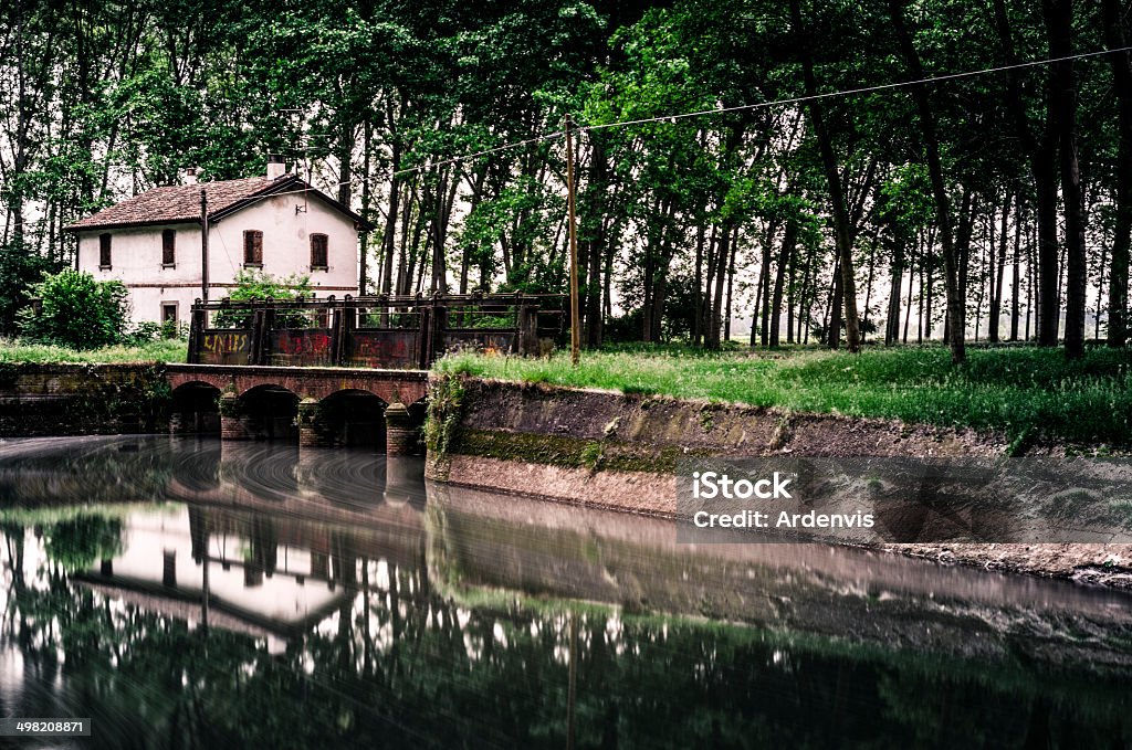 Vecchia casa e dike su un fiume, lunga esposizione - Foto stock royalty-free di Abbandonato