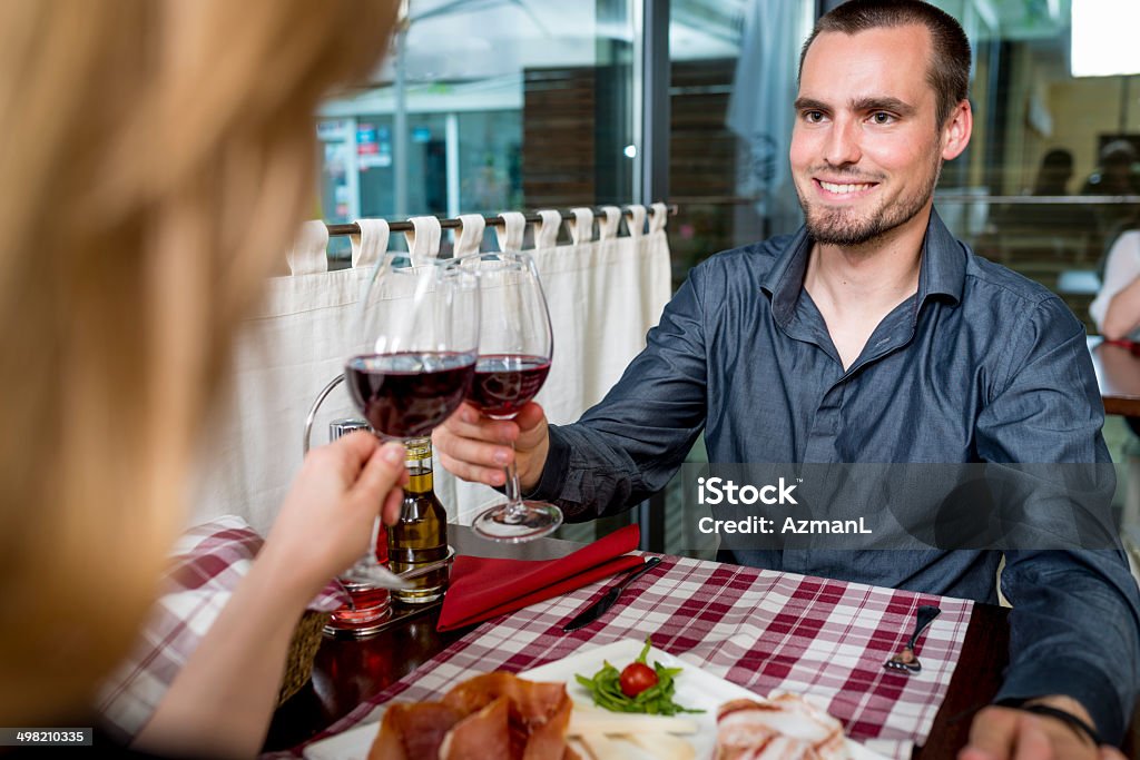 Couple toasting Young couple having a glass of wine in a restaurant. 25-29 Years Stock Photo