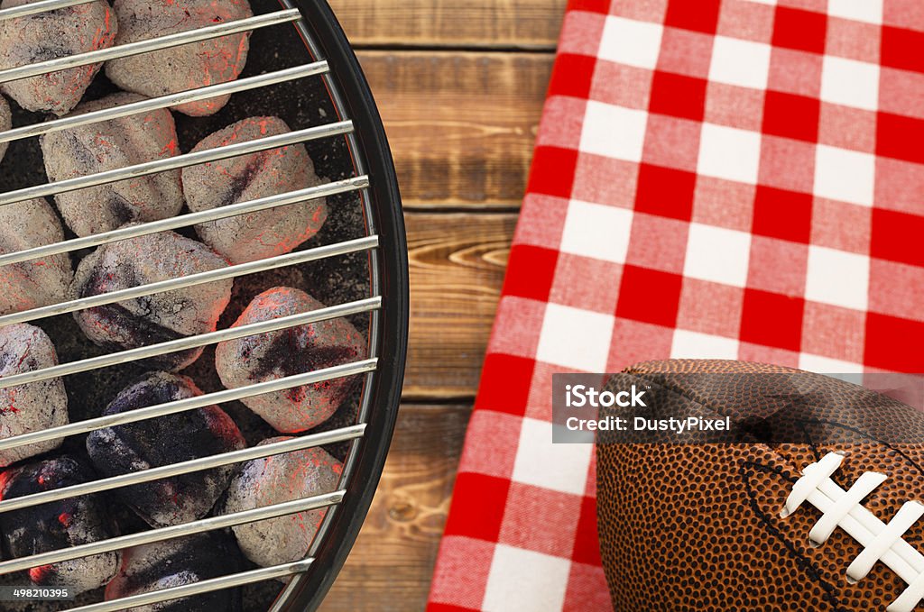 Football Tailgate Party Grill with glowing charcoal briquettes and football Tailgate Party Stock Photo