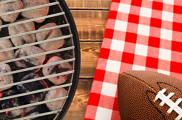 Grill with glowing charcoal briquettes and football