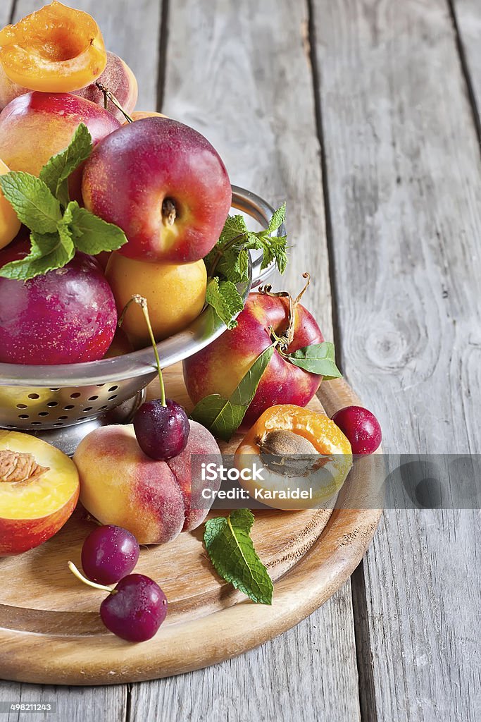 Apricots, nectarines and saturn peaches background Ripe apricots, nectarines and saturn peaches in steel colander. Selective focus. Copy space background. Agriculture Stock Photo
